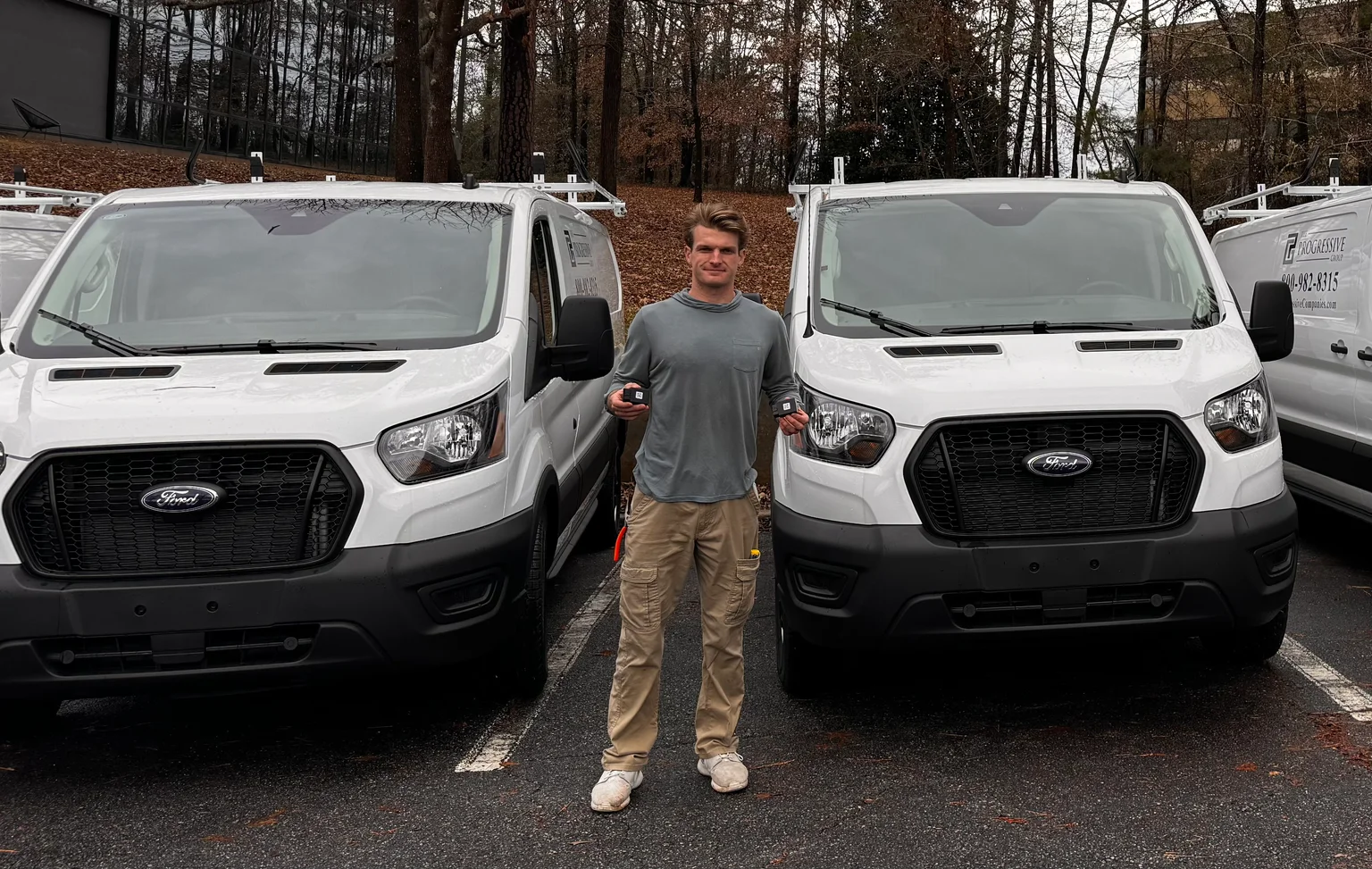 Matthew standing beside a fleet of tracked work vans
